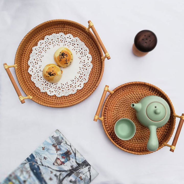 Wicker trays with tea set and pastries on a white background