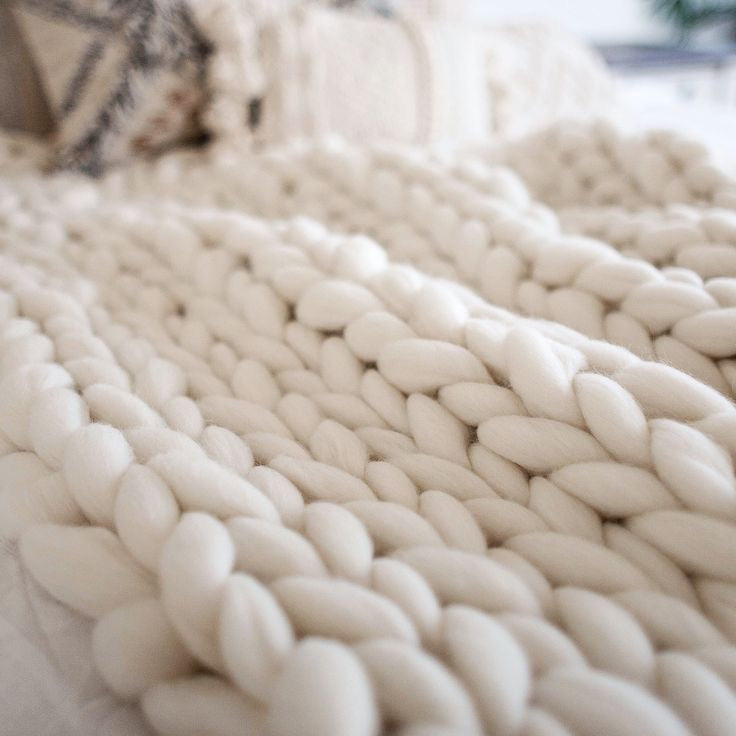 Close-up of a textured white blanket with a blurred background