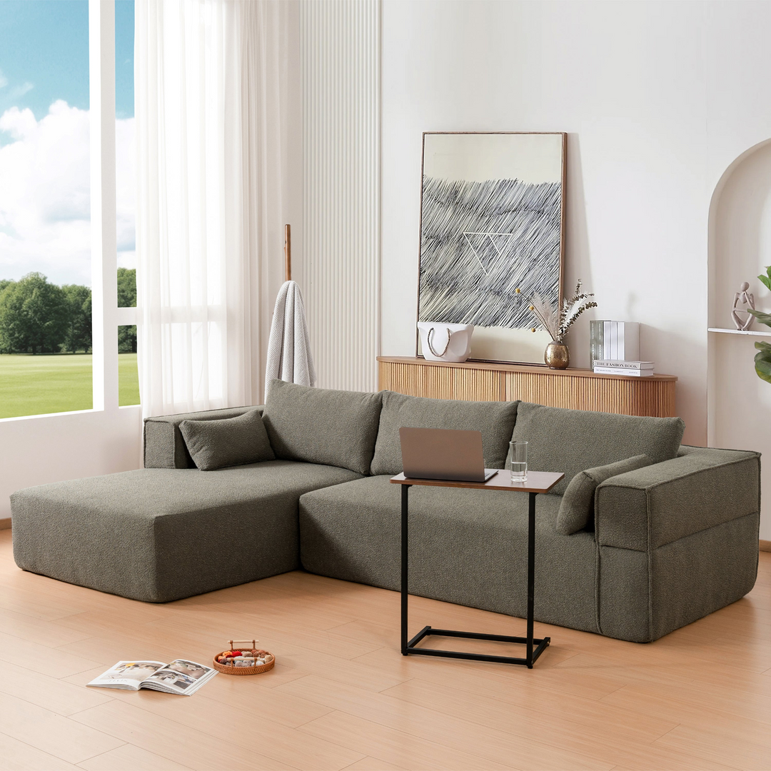 Modern living room with a gray sectional sofa, coffee table, and decor items.