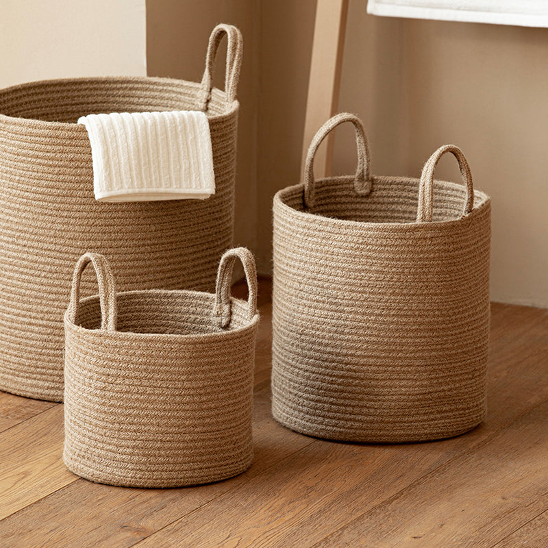 Three woven baskets of different sizes on a wooden floor.