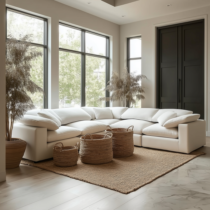 Large White Modern living room with a white sectional sofa, wicker baskets, and large windows.