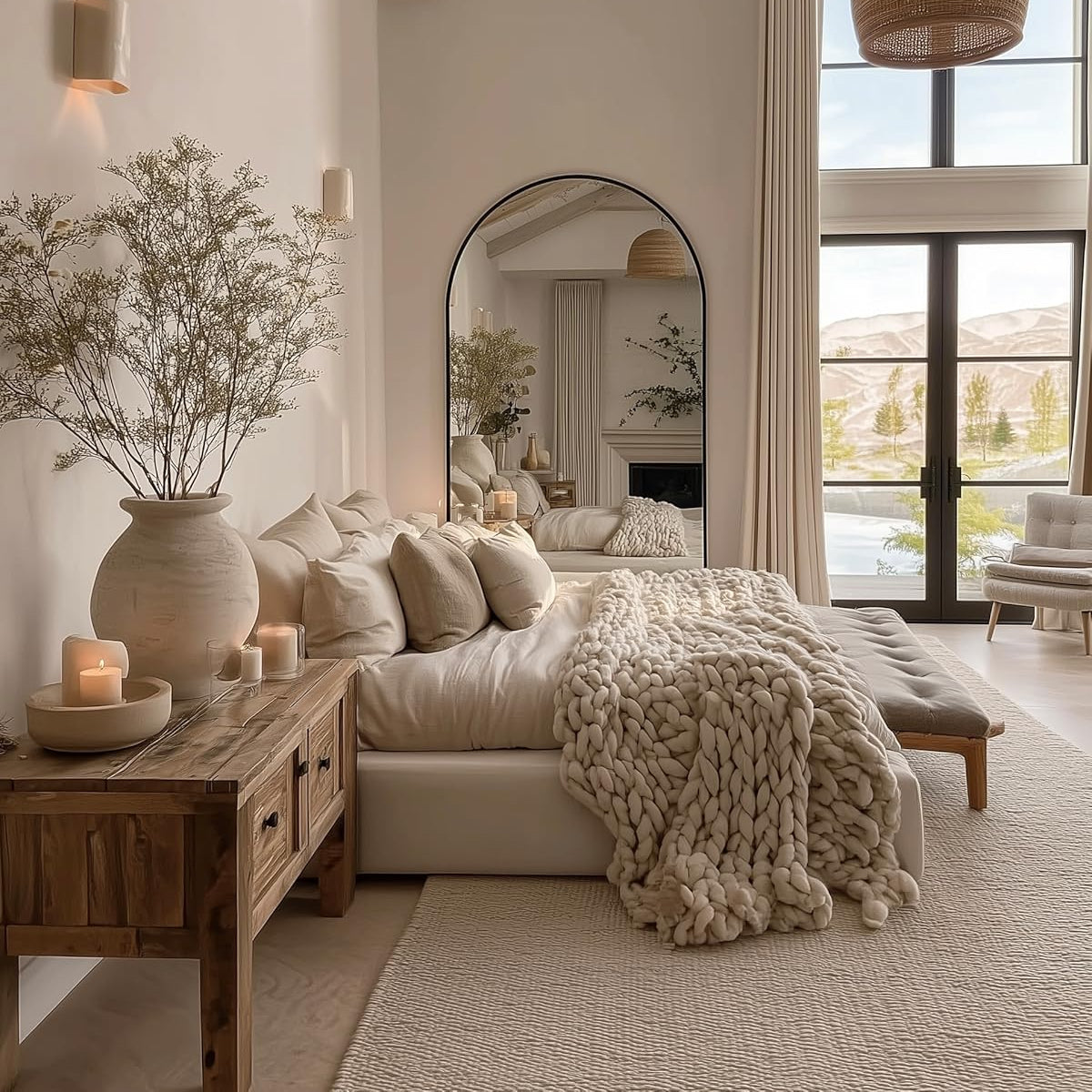 Cozy bedroom with neutral tones, large mirror, and natural light.